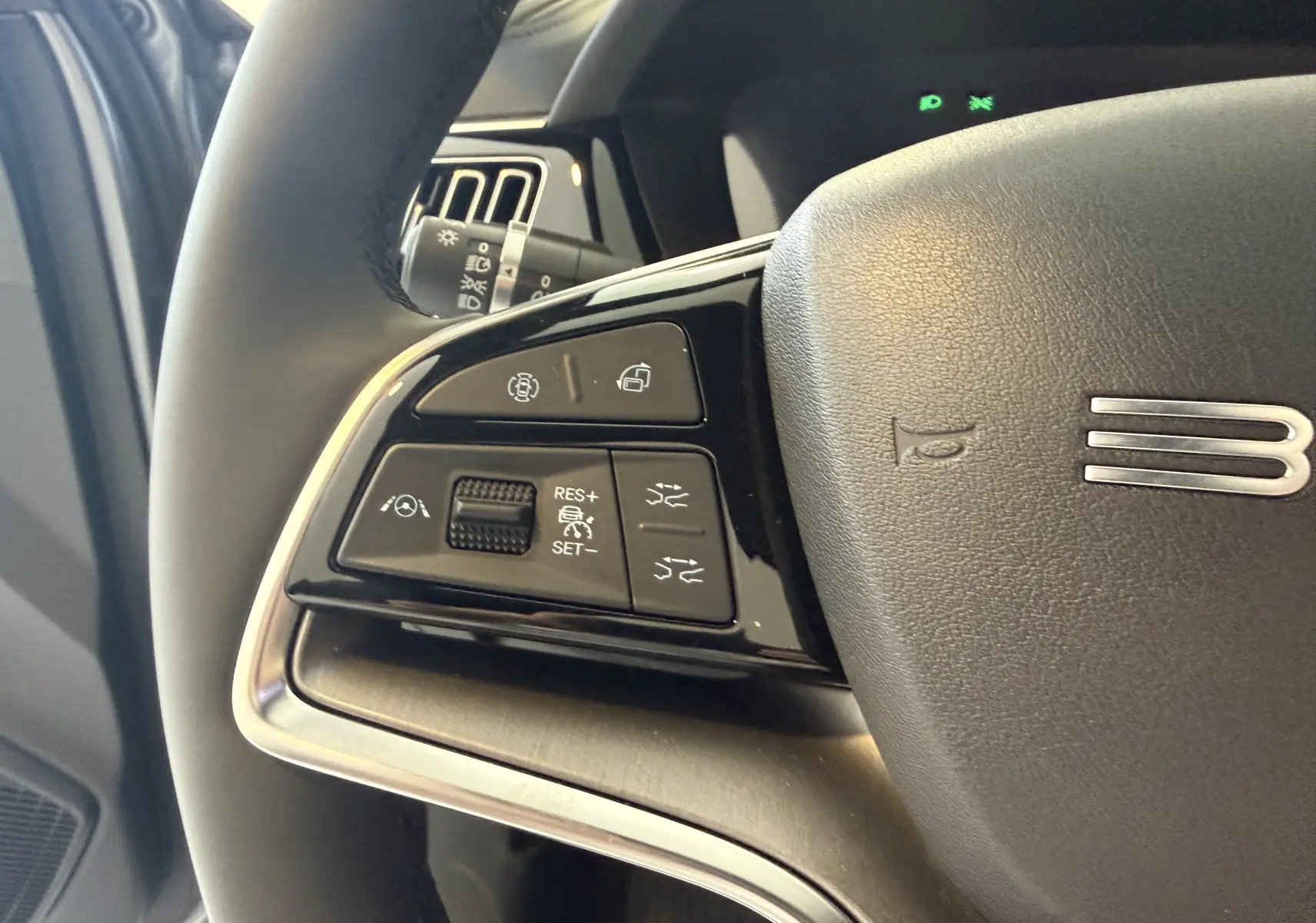Gros plan sur les commandes au volant côté gauche du BYD SEAL U 2026, finition noire avec détails chromés.