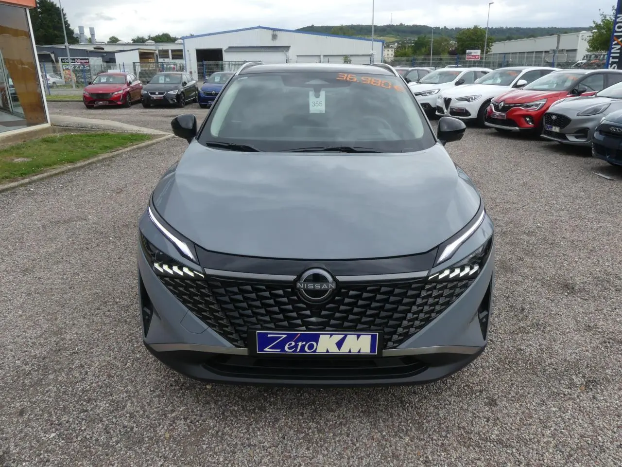 Vue de face du Nissan Qashqai 1.5 e-Power gris métallisé avec calandre noire et feux LED distinctifs.