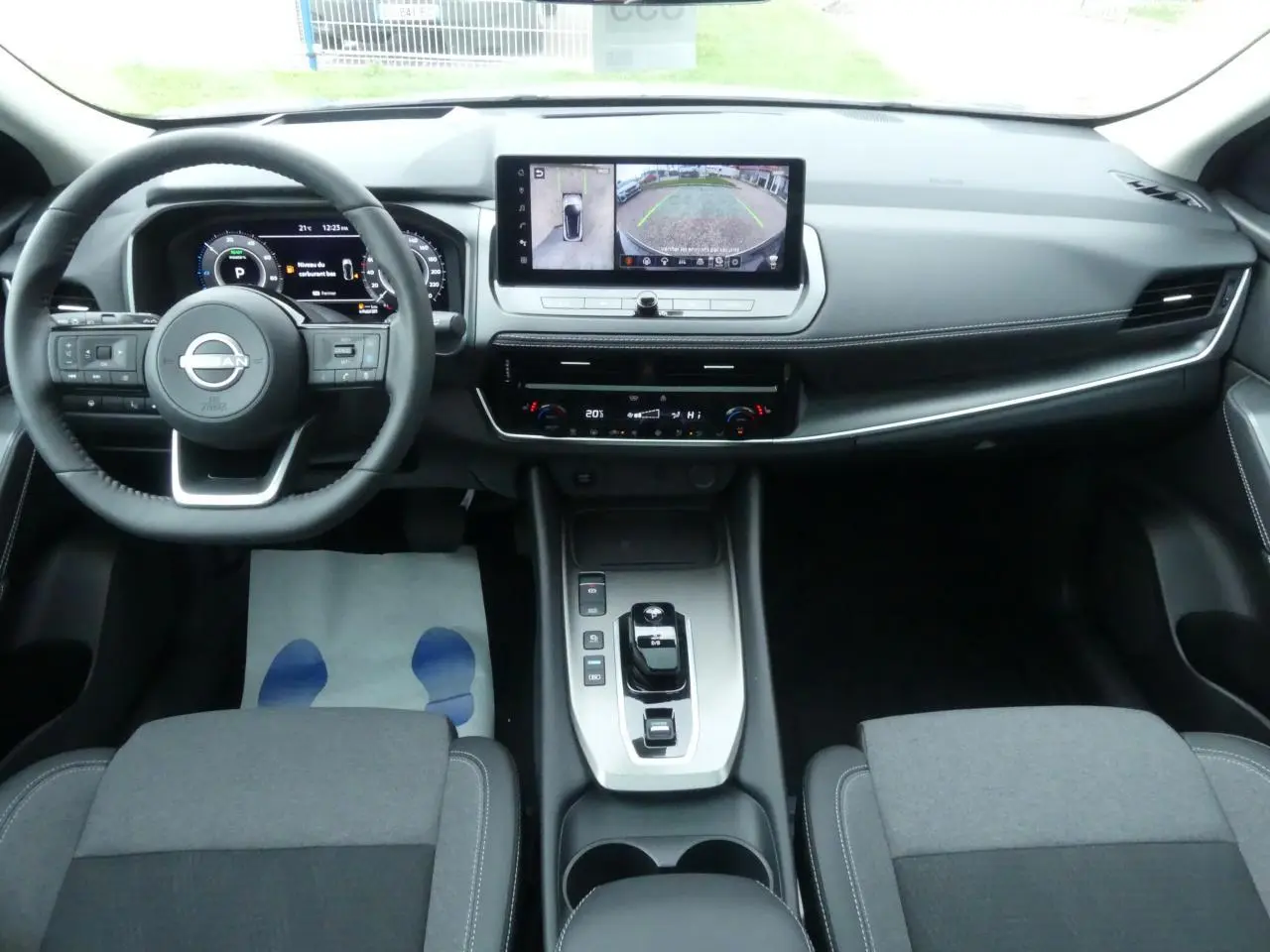 Vue intérieure du tableau de bord et console centrale du Nissan Qashqai 2025, finition N-Connecta, avec écran tactile et volant cuir.