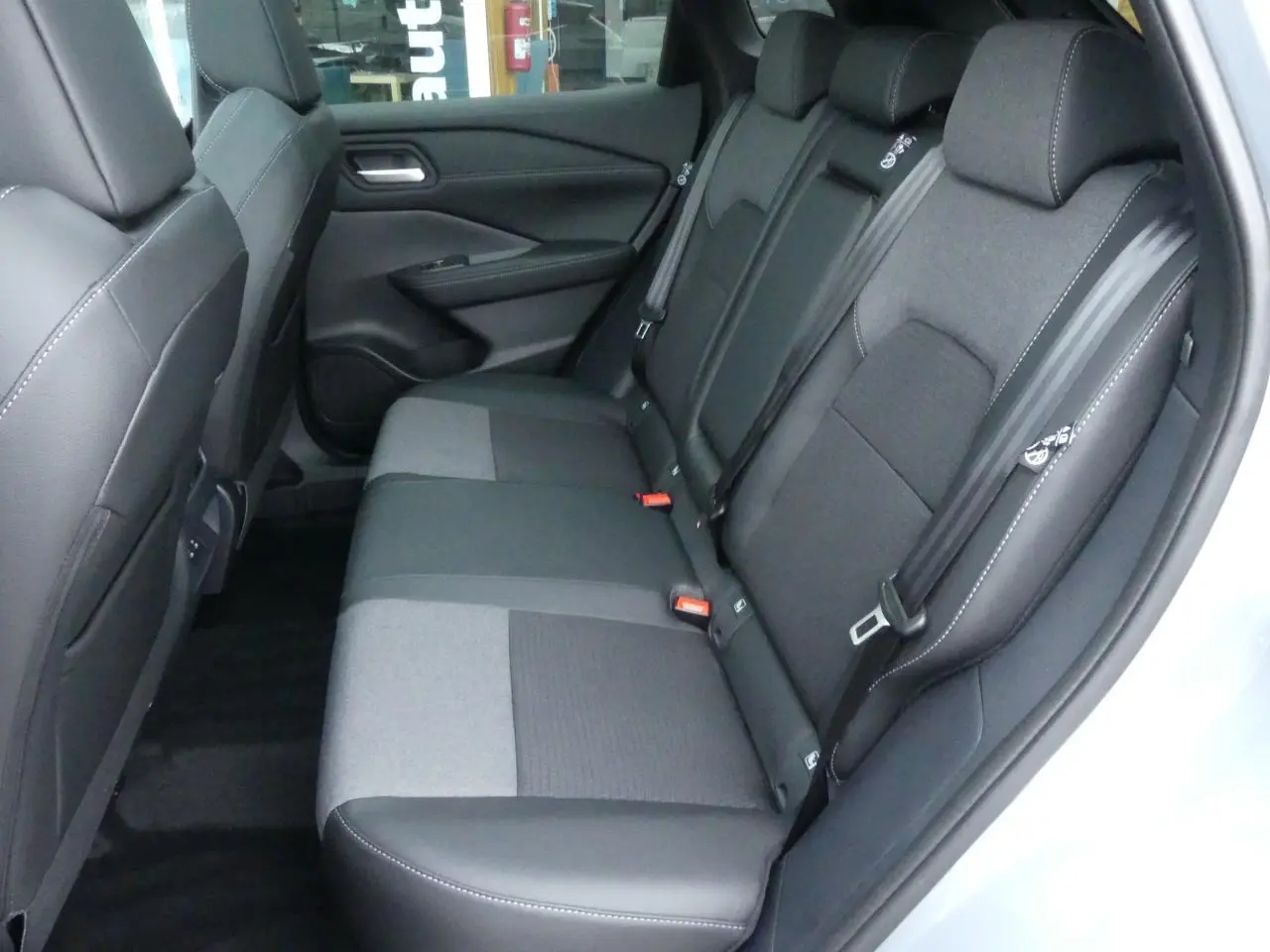 Banquette arrière en tissu et TEP noir avec surpiqûres blanches dans un Nissan Qashqai 1.5 e-Power gris métallisé, vue côté droit.