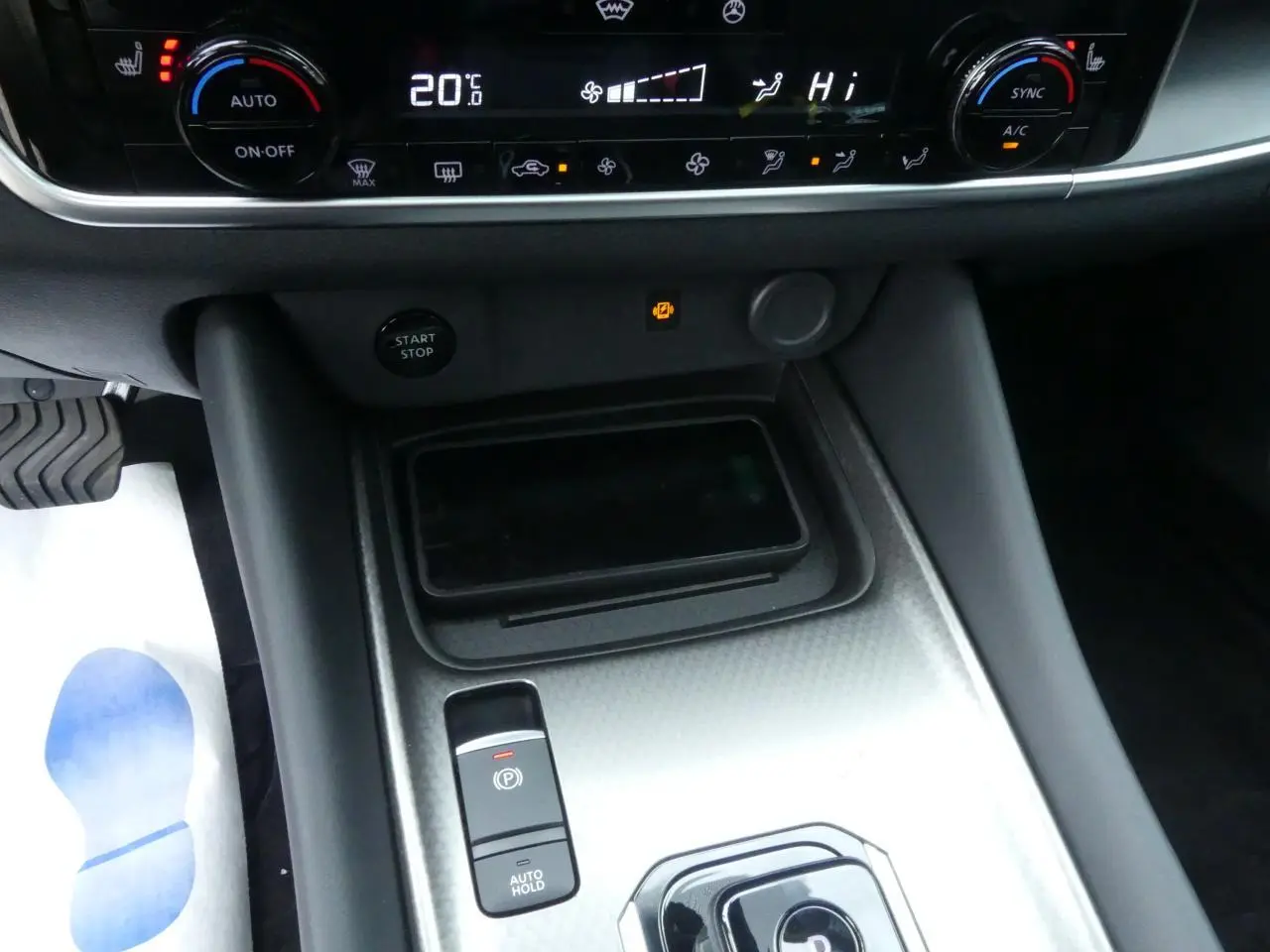 Gros plan sur la console centrale du Nissan Qashqai 1.5 e-Power 2025 avec commandes climatisation et frein électrique.