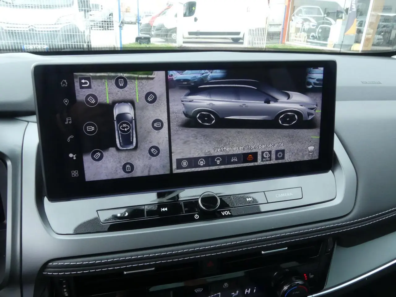 Écran central affichant la vue 3D latérale droite et vue aérienne du Nissan Qashqai gris métallisé en stationnement