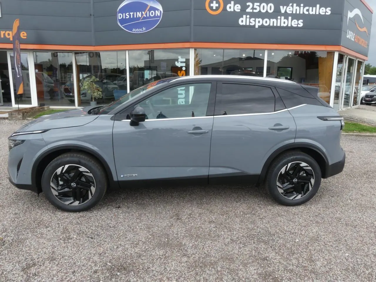 Profil côté gauche du Nissan Qashqai 1.5 e-Power gris métallisé avec toit noir et jantes alliage 18 pouces.