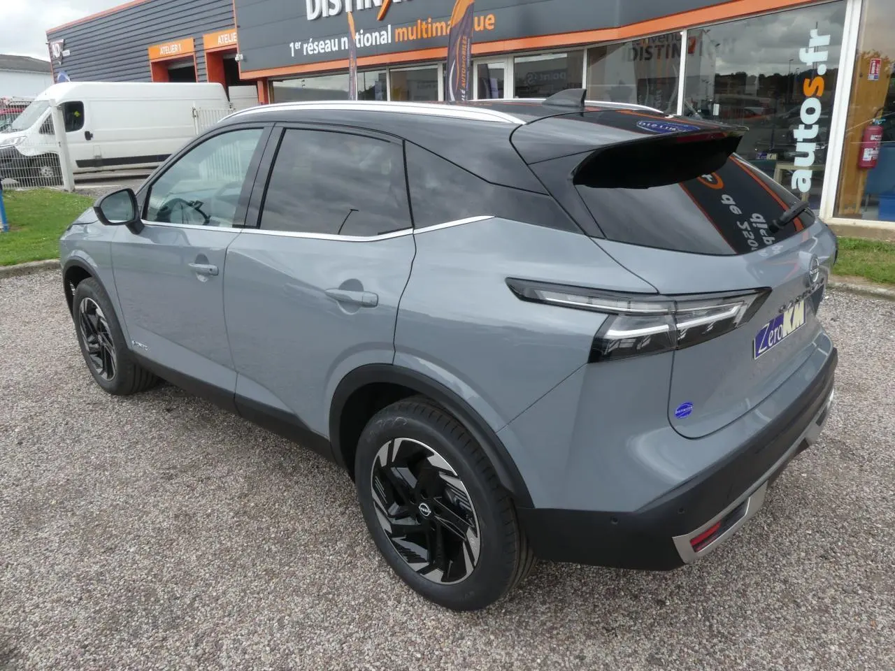 Vue 3/4 arrière droit du Nissan Qashqai 1.5 e-Power gris métallisé avec toit noir et jantes alliage noires.
