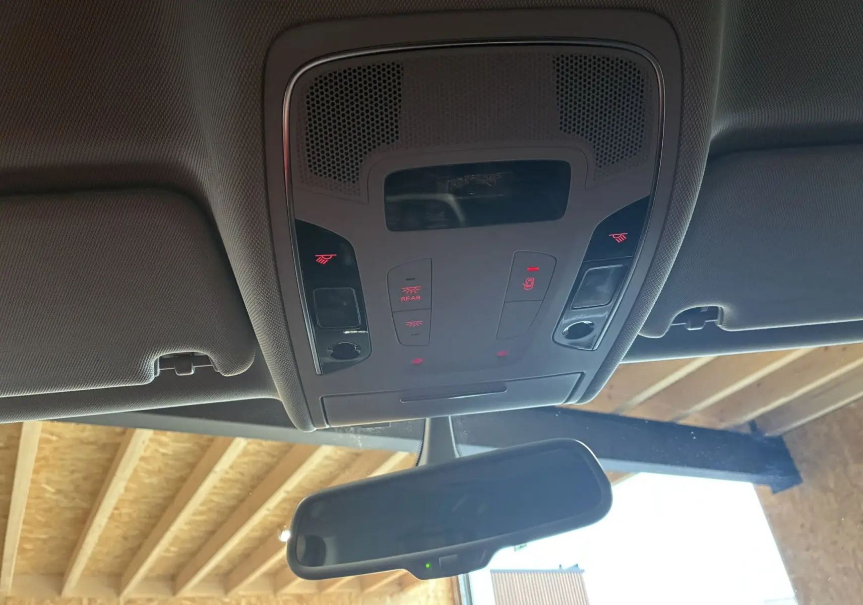 Vue intérieure du plafonnier et du rétroviseur intérieur d'une Audi A6 Avant noire de 2017, avec commandes éclairées.