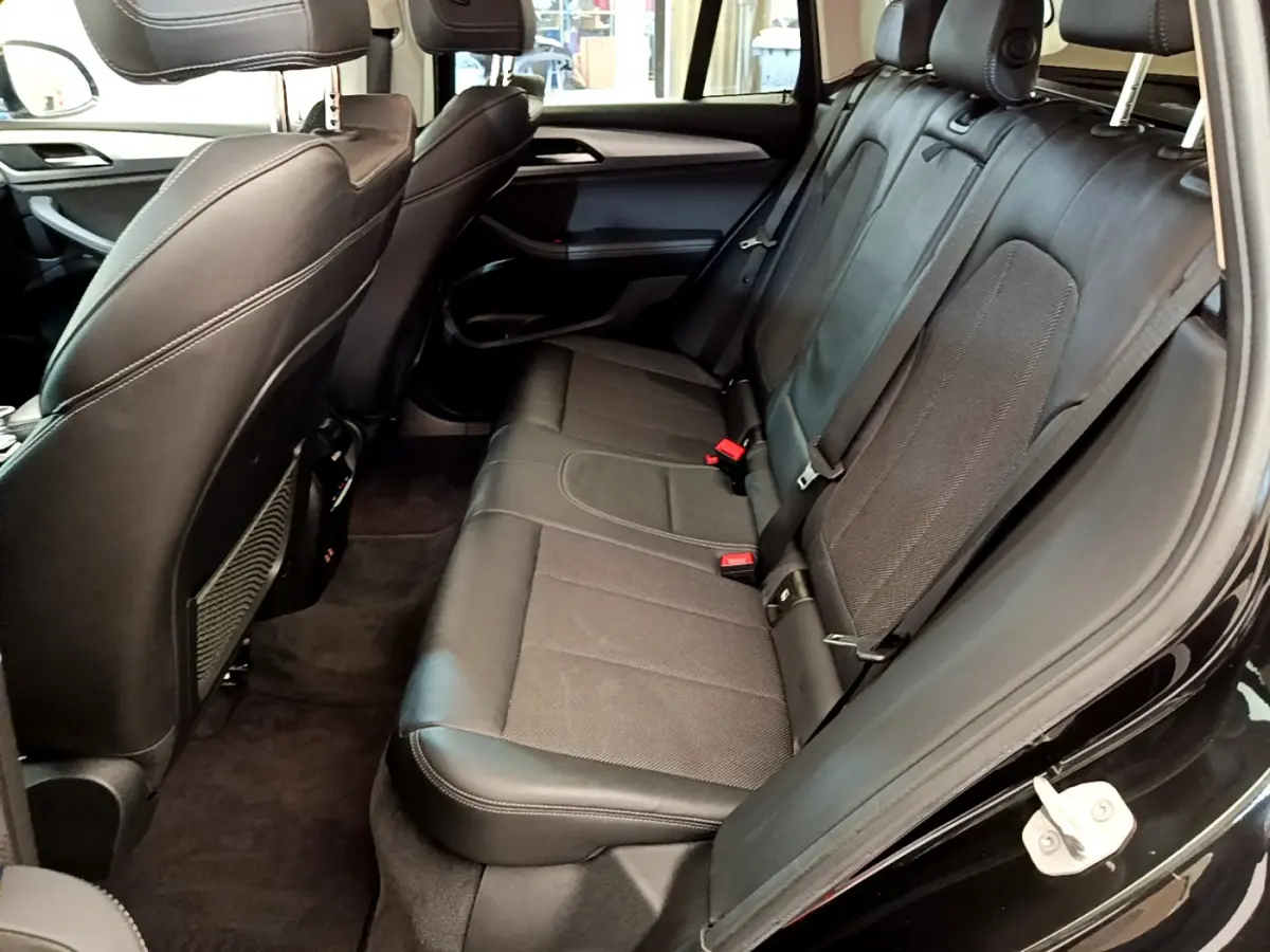 Vue intérieure côté droit sur la banquette arrière en cuir noir du BMW X3 xDrive20d Lounge 2020.