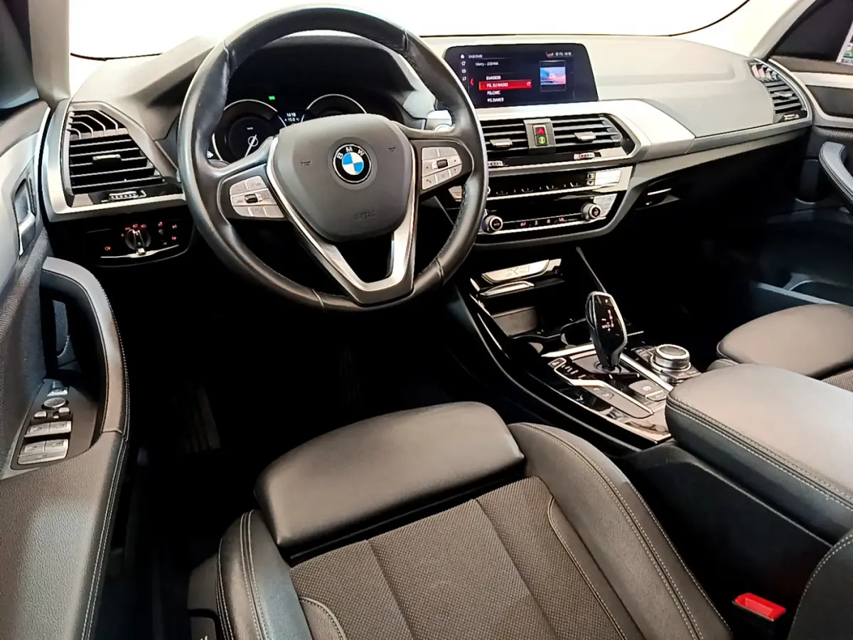 Intérieur noir du BMW X3 xDrive20d 2020 vu côté conducteur, volant cuir multifonctions et écran central 8,8 pouces.