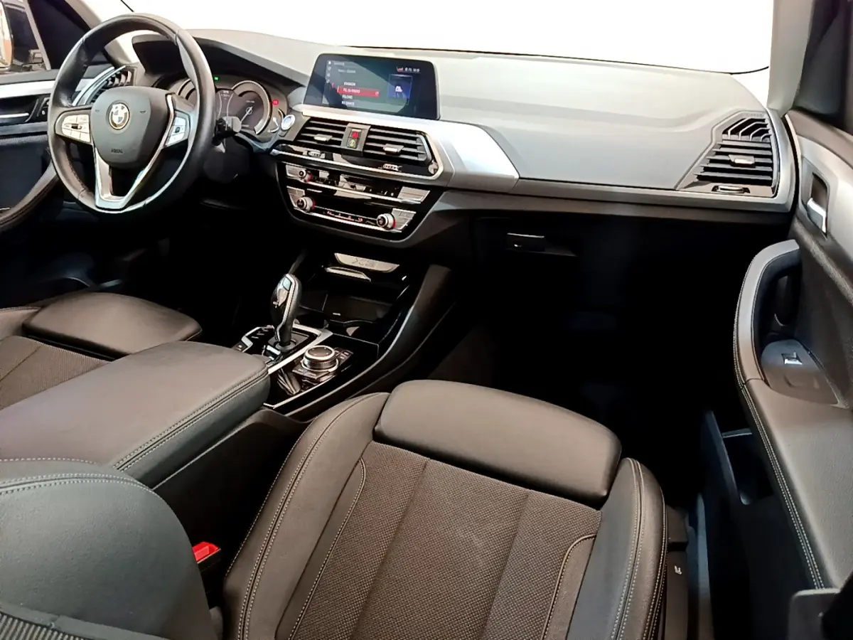 Intérieur noir du BMW X3 xDrive20d 2020, vue côté passager avant sur tableau de bord et console centrale.