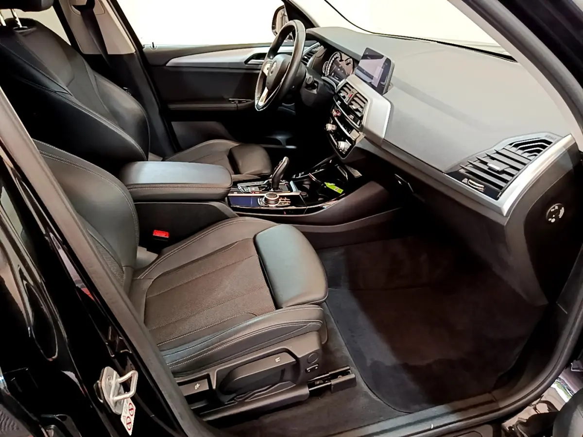 Intérieur avant droit BMW X3 xDrive20d 2020 noir, sièges cuir, tableau de bord moderne avec écran central et console élégante.