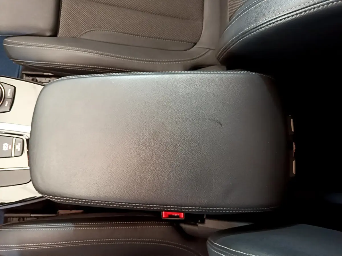 Vue plongeante sur l'accoudoir central en cuir noir avec surpiqûres blanches du BMW X3 xDrive20d 2020.