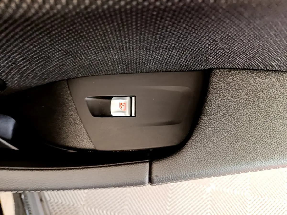 Gros plan sur le bouton de verrouillage des vitres côté intérieur d'une BMW X3 noire xDrive20d 2020.