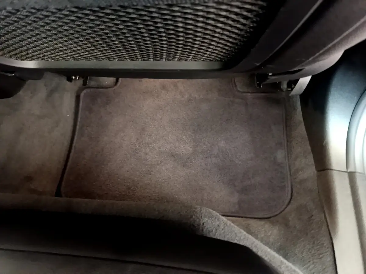 Tapis de sol gris foncé côté passager arrière d'un BMW X3 xDrive20d 2020, avec filet de rangement sous le siège.