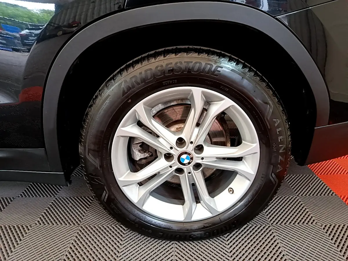Gros plan sur la roue avant droite noire du BMW X3 xDrive20d 2020 avec jante alliage et pneu Bridgestone Alenza.