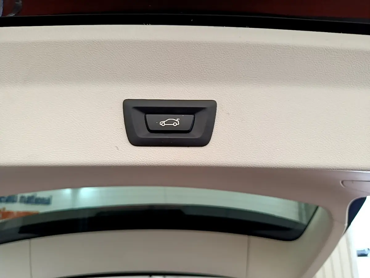 Bouton d'ouverture électrique du coffre sur la partie intérieure du hayon d'un BMW X3 noir xDrive20d 2020.