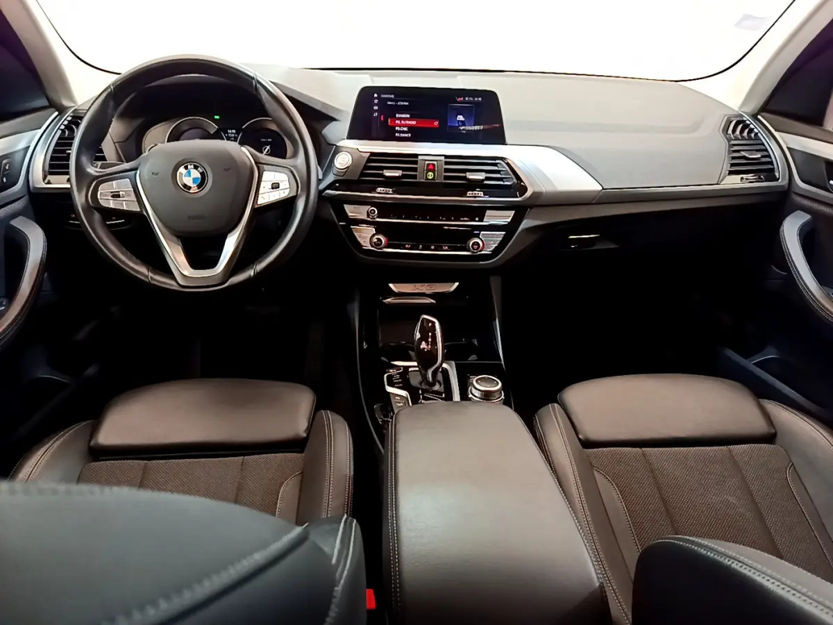 Vue intérieure frontale du tableau de bord et volant cuir noir du BMW X3 xDrive20d 2020 avec écran tactile central et console moderne.