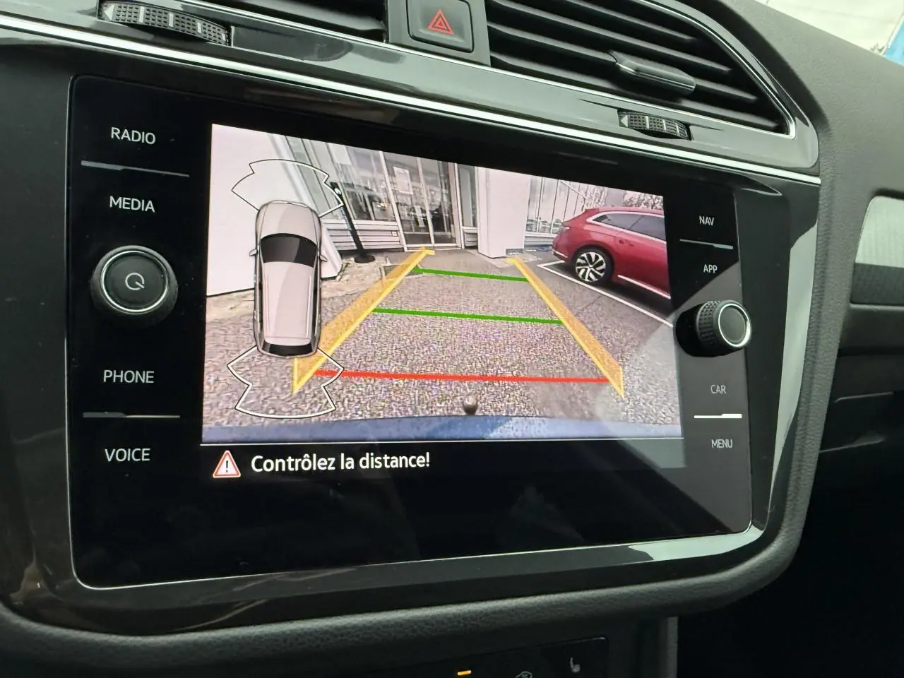 Vue rapprochée de l'écran de la caméra de recul du Volkswagen Tiguan 2022 avec affichage des lignes de guidage colorées.