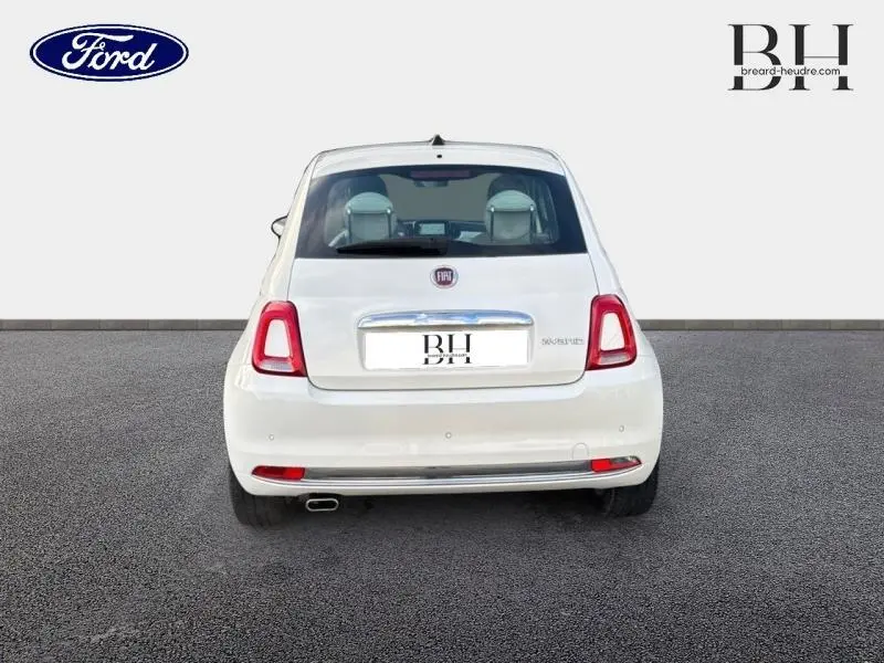 Vue arrière d'une Fiat 500 blanche Bossa Nova Pastel avec feux rouges et échappement visible côté gauche.