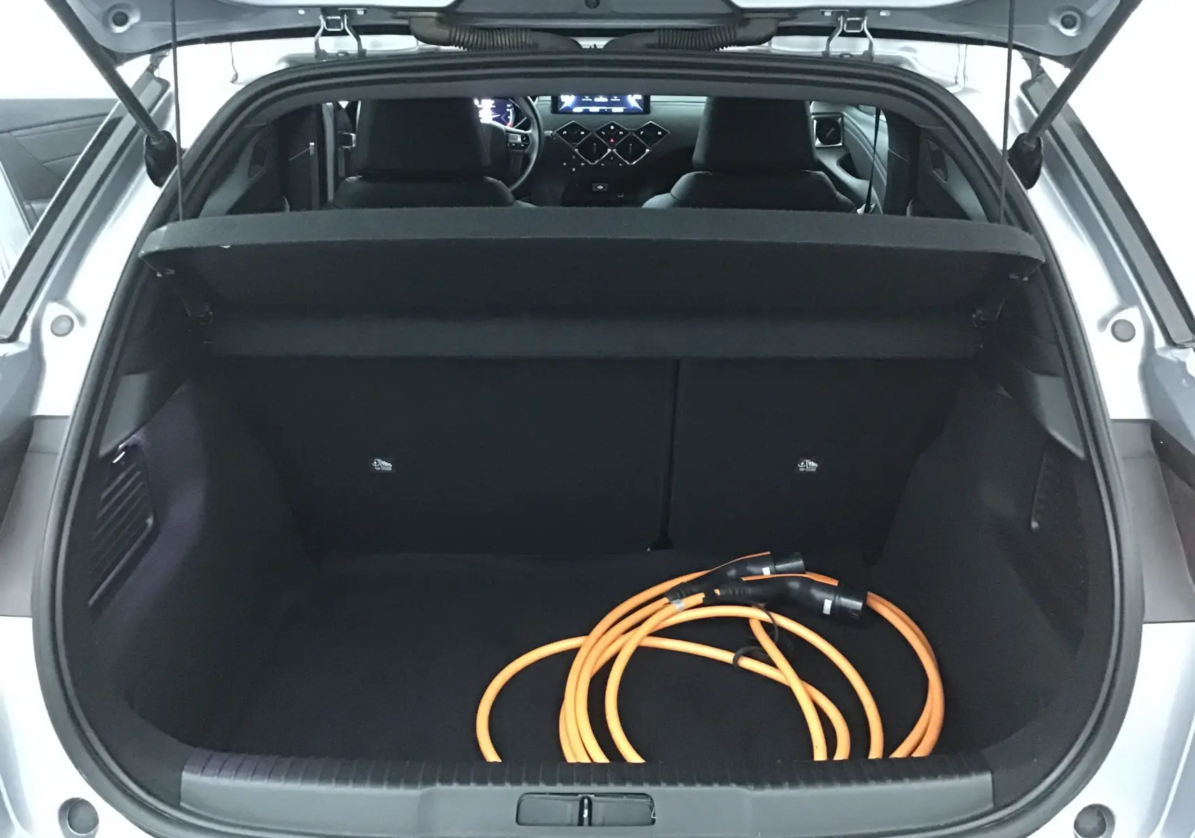 Coffre ouvert d’un DS3 Crossback gris Artense 2021 avec câble de recharge électrique visible au sol.