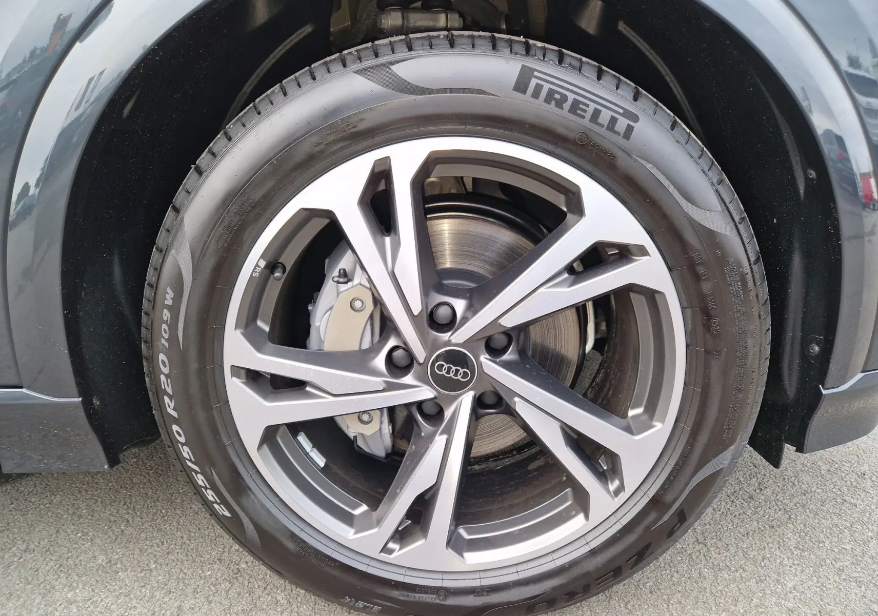 Gros plan sur la jante Audi Sport en alliage gris et noir du Q6 e-tron Performance S-Line gris Manhattan, avec pneu Pirelli.