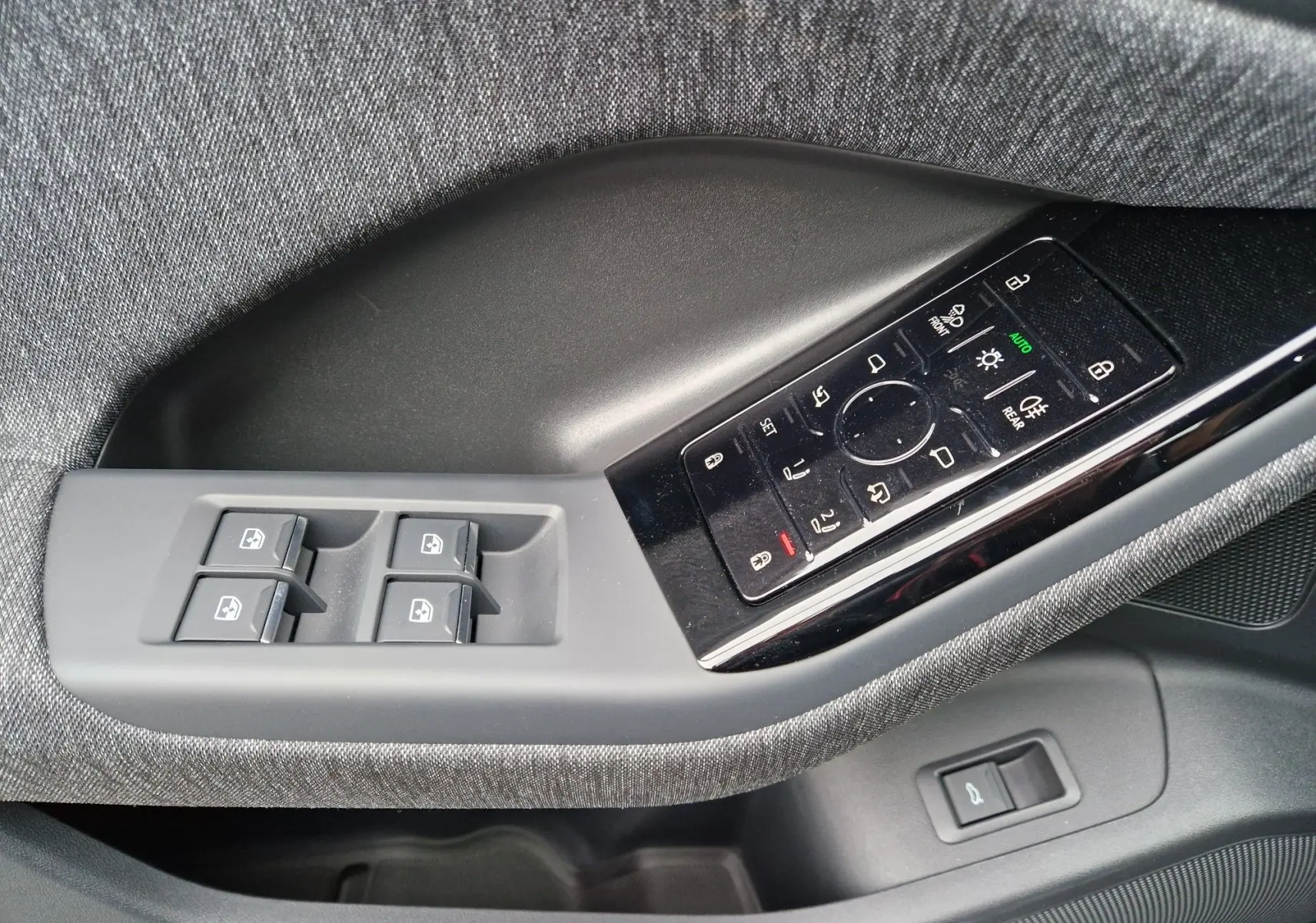 Panneau de commandes côté gauche avec boutons de vitres et réglages des rétroviseurs sur Audi Q6 e-tron gris Manhattan.