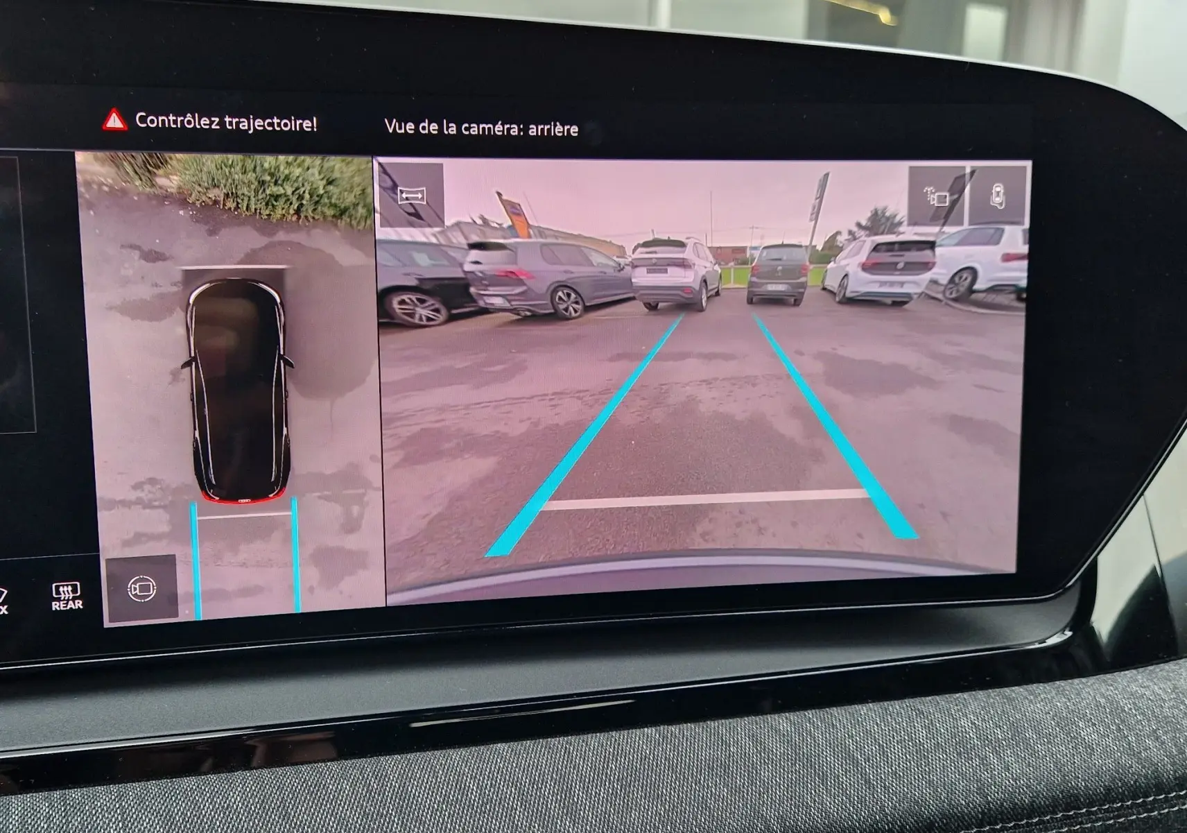 Affichage de la caméra de recul et vue 360° sur l'écran du tableau de bord de l'Audi Q6 e-tron gris Manhattan, version 2025.