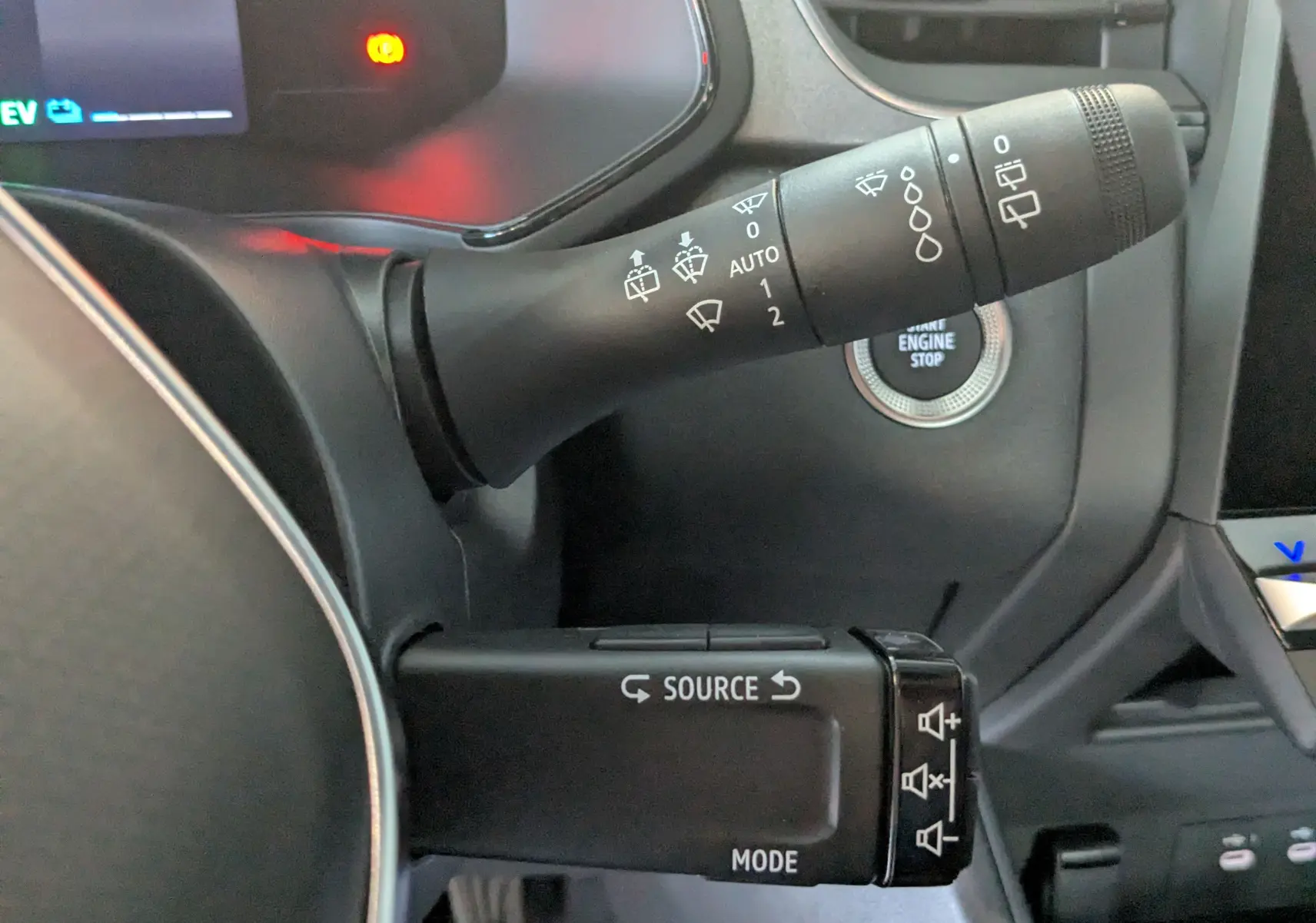 Gros plan sur les commandes au volant du Renault Captur gris Cassiopée 2025, avec bouton start/stop visible.