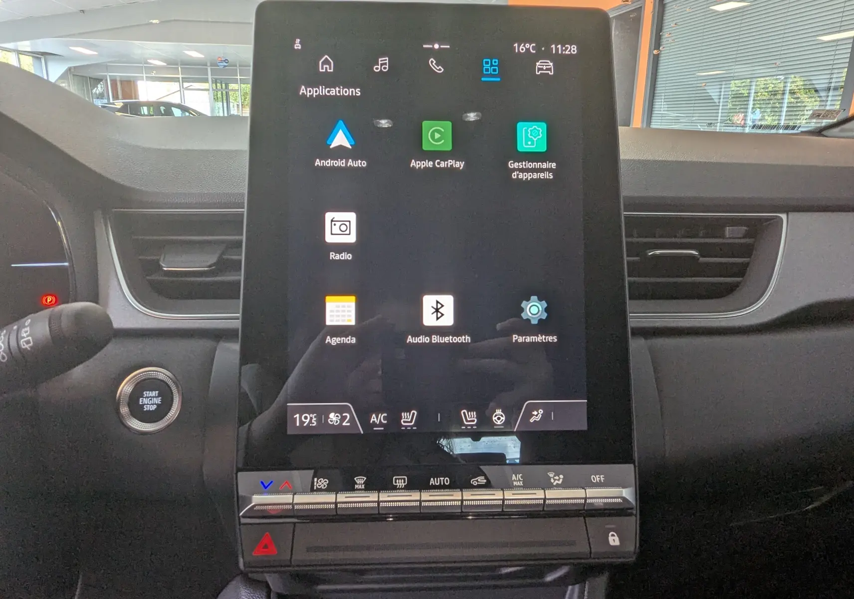 Écran tactile central du Renault Captur E-Tech 2025 affichant les applications Android Auto et Apple CarPlay, intérieur gris.