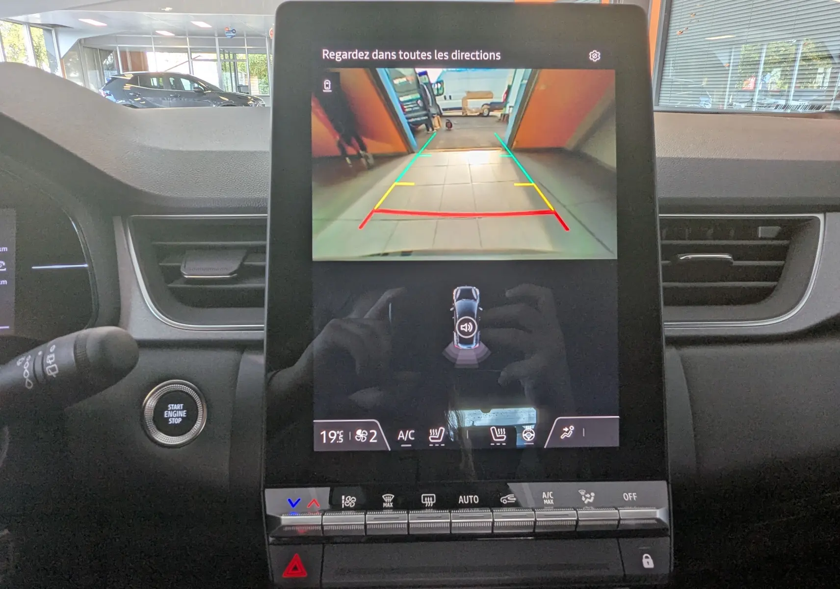 Écran central du Renault Captur E-Tech Hybrid 2025 montrant la caméra de recul avec commandes climatisation et tableau de bord gris.