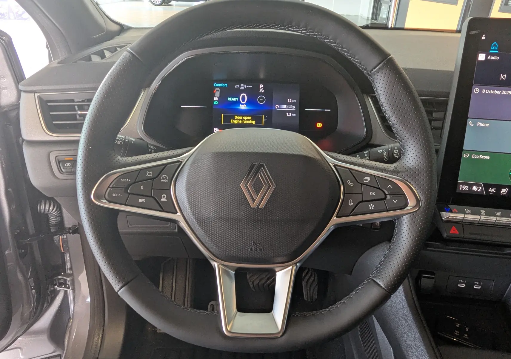Vue rapprochée du volant multifonction noir avec logo Renault au centre du tableau de bord du Captur E-Tech 2025.