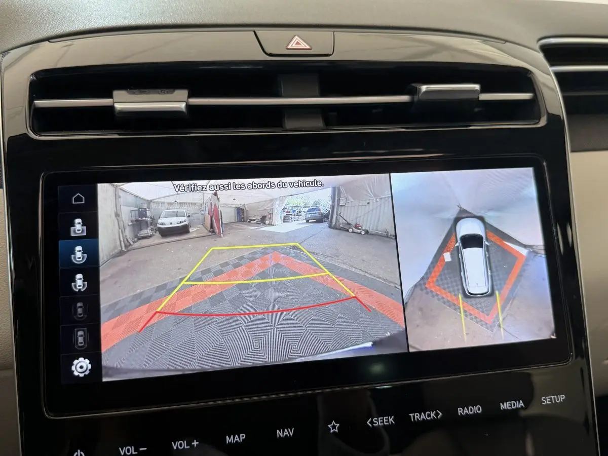 Écran tactile intérieur montrant la caméra de recul et vue à 360° du Hyundai Tucson noir en stationnement.