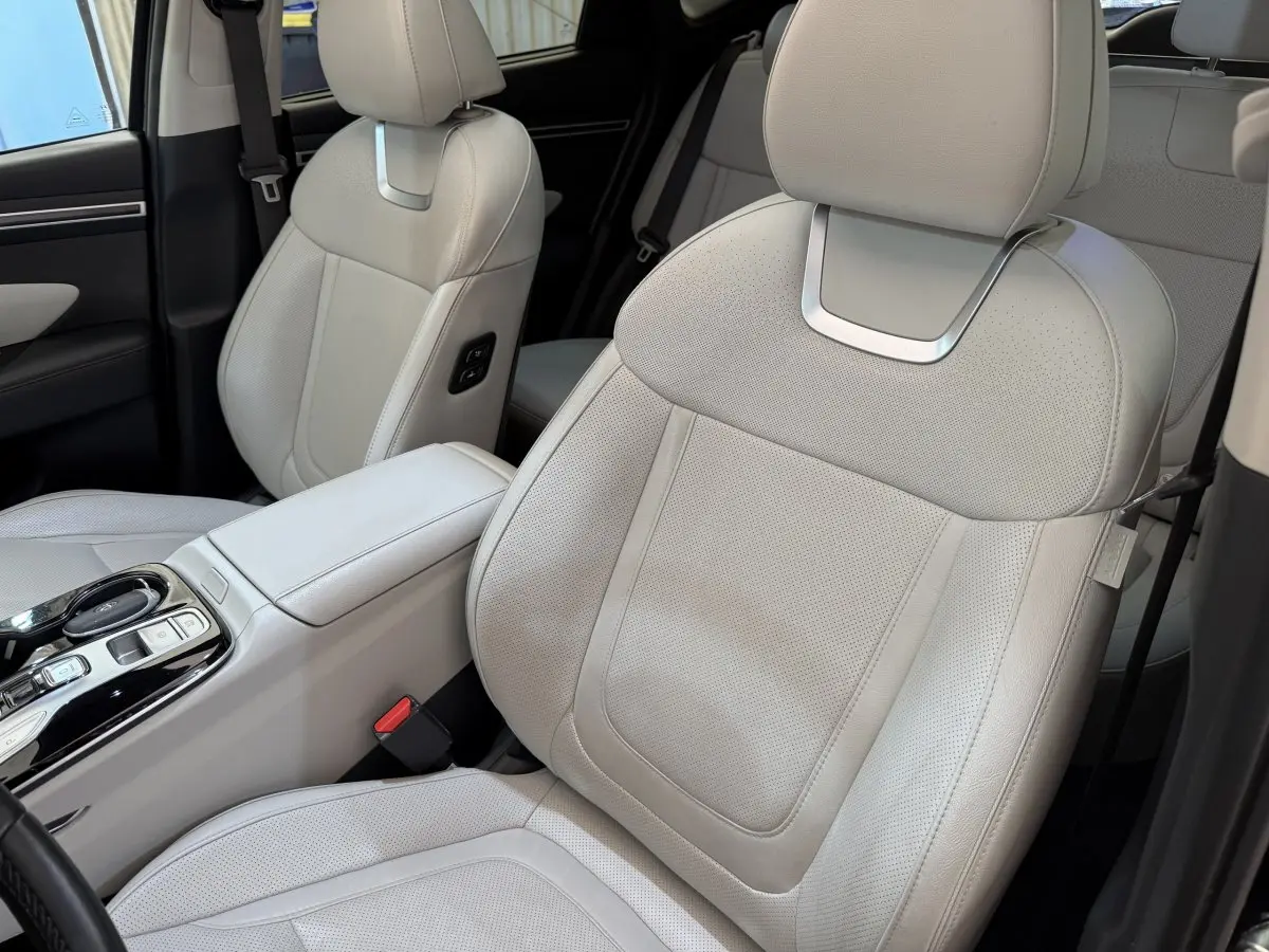 Gros plan sur les sièges avant en cuir beige clair du Hyundai Tucson 2022, avec console centrale visible.
