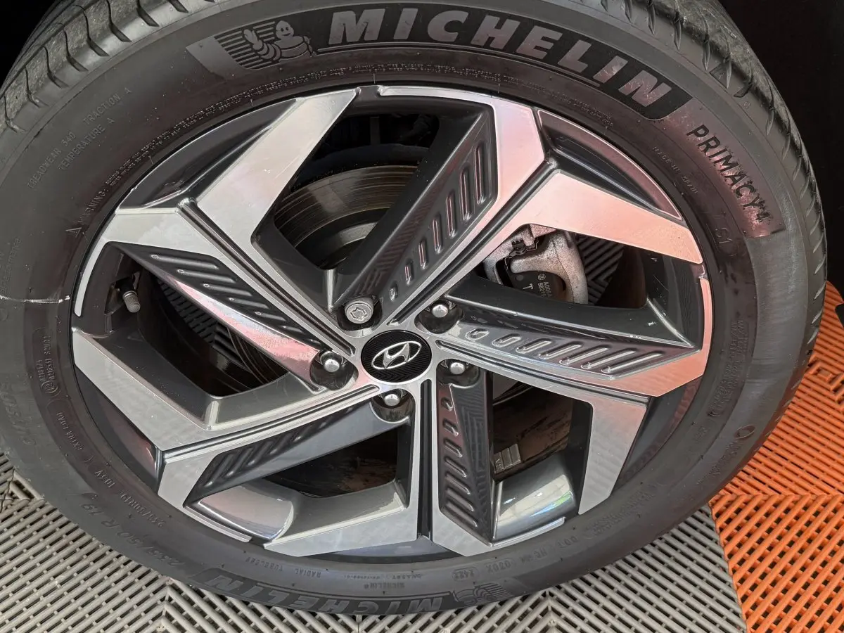 Gros plan sur la roue avant droite du Hyundai Tucson noir 2022 avec jante alliage et pneu Michelin Primacy.