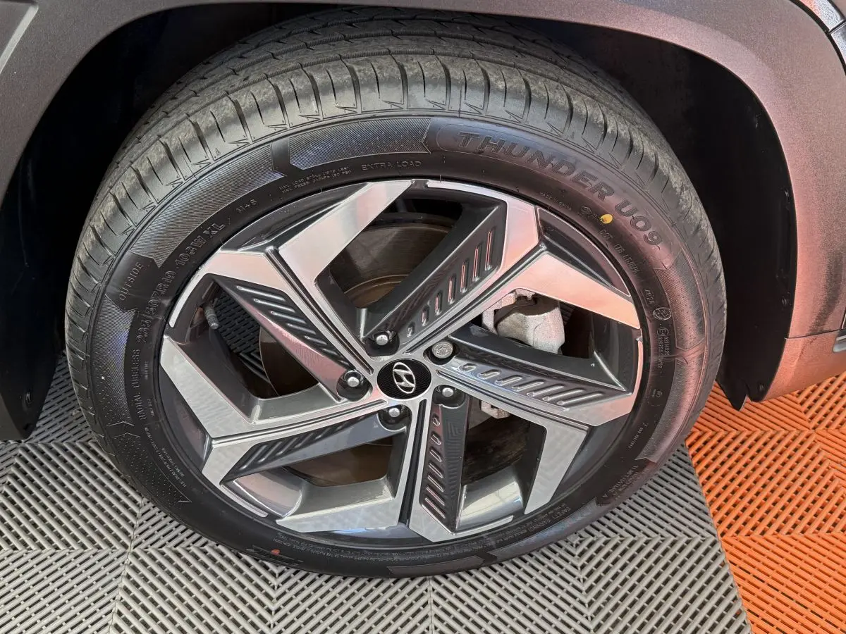 Gros plan sur la roue avant droite du Hyundai Tucson noir, mettant en valeur la jante alliage moderne et le pneu Thunder U09.