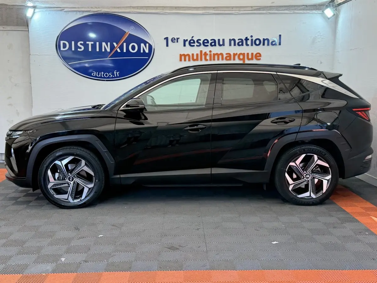 Profil côté gauche d'un Hyundai Tucson noir 2022 avec jantes alliage et toit ouvrant électrique en verre.