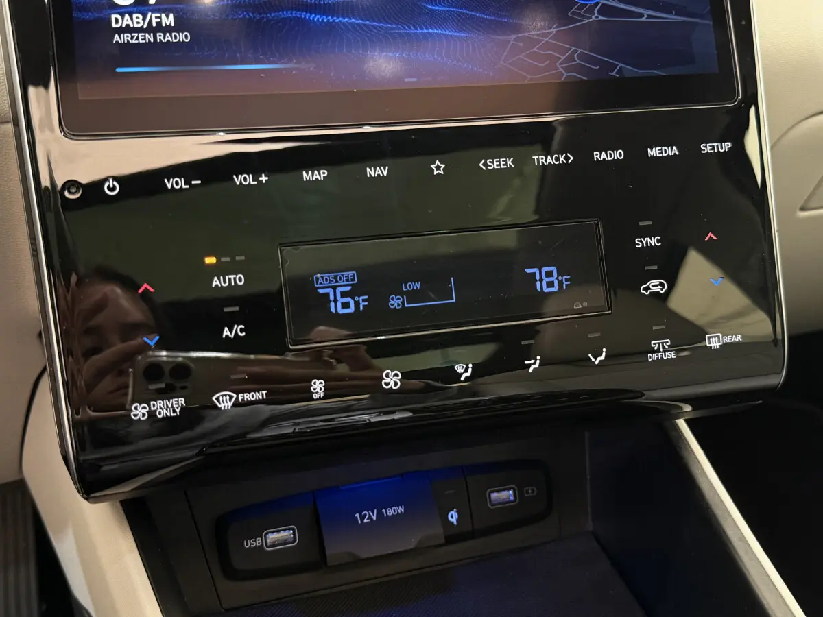 Détail du tableau de bord noir brillant du Hyundai Tucson 2022 avec écran tactile et commandes climatisation digitales.