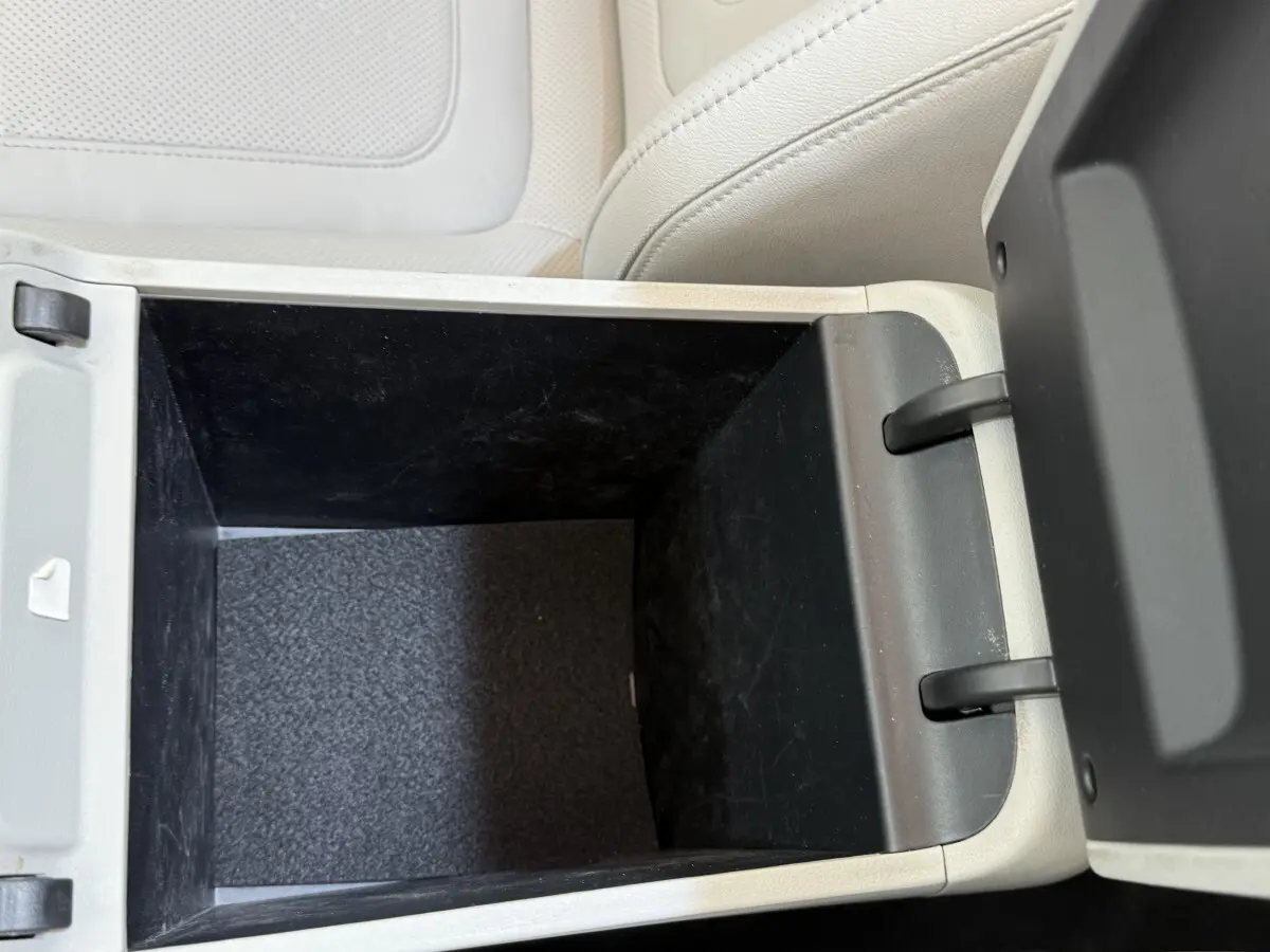 Intérieur du coffre central beige ouvert du Hyundai Tucson 2022, montrant un espace de rangement profond et noir.