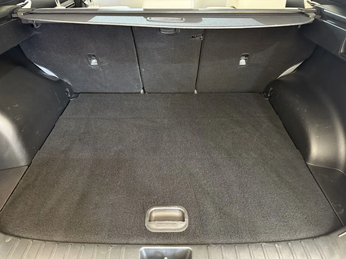 Coffre noir du Hyundai Tucson 2022 vu de face, avec tablette cache-bagages et tapis de sol propre.