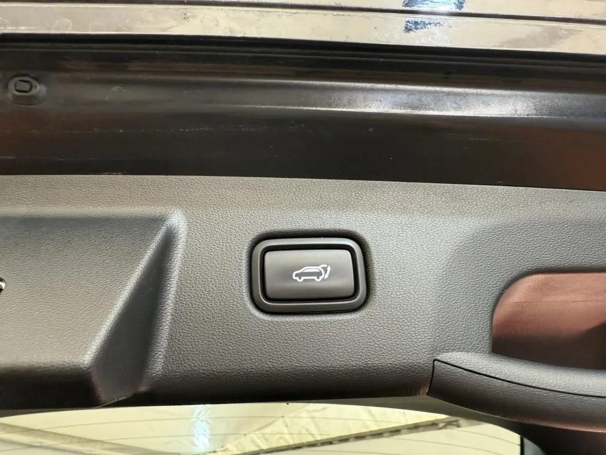 Bouton d'ouverture électrique du coffre sur la garniture intérieure du hayon d'un Hyundai Tucson noir 2022.