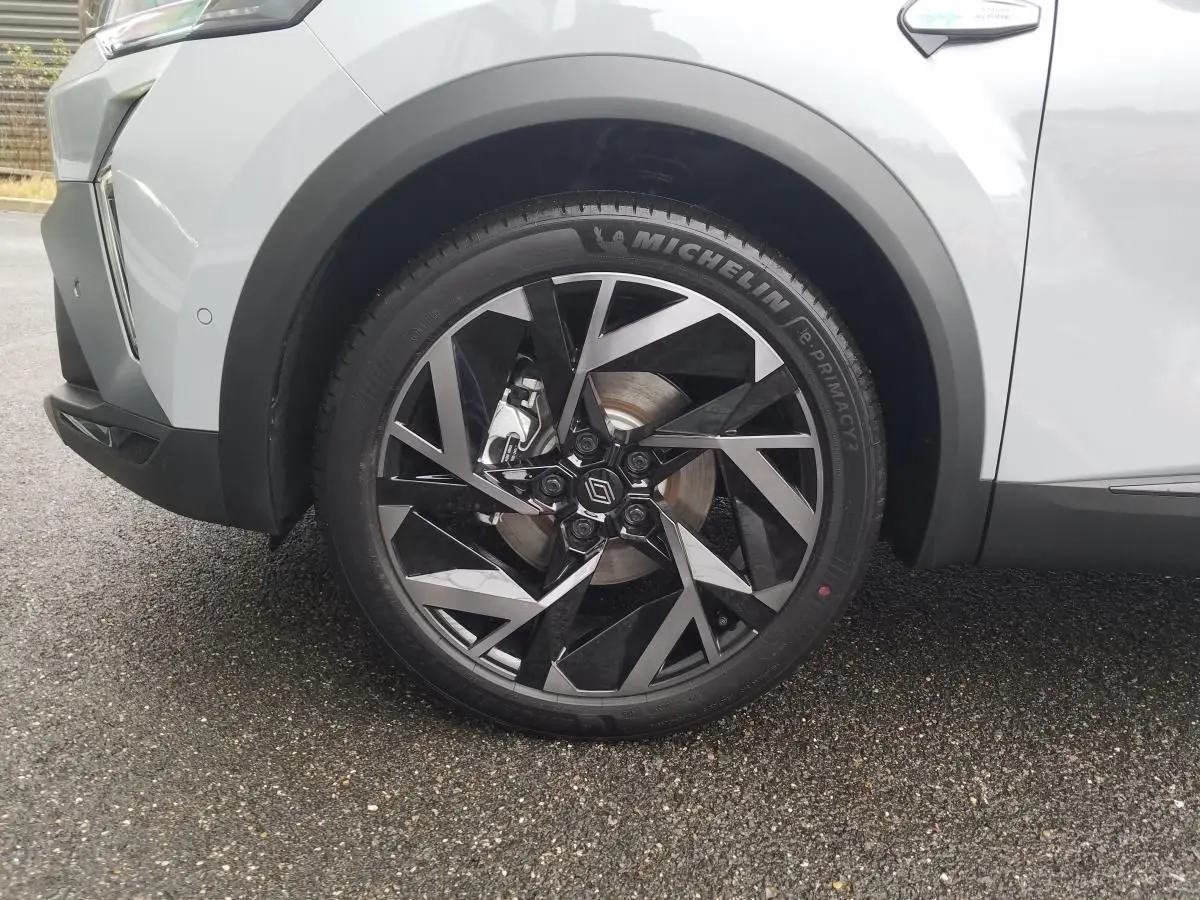 Gros plan sur la roue avant gauche du Renault Captur gris Rafale 2025 avec jante alliage 19 pouces au design géométrique.