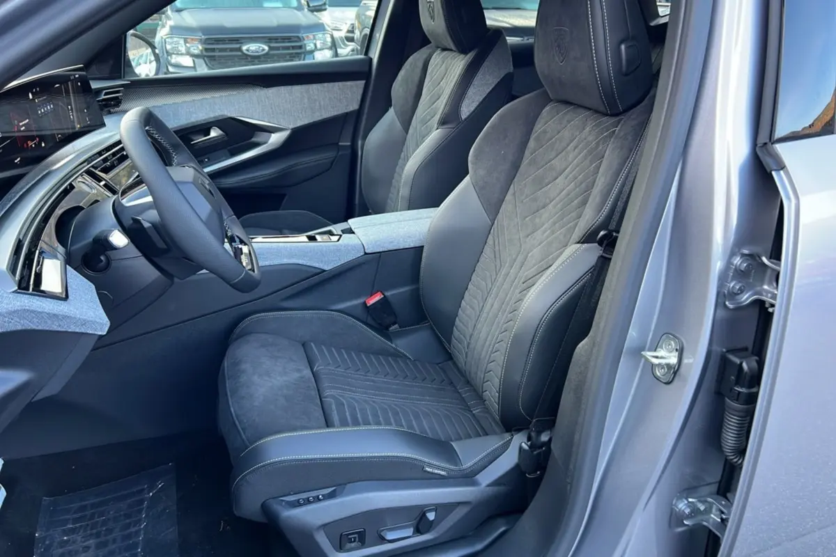 Vue intérieure côté conducteur du Peugeot 3008 Hybrid 145 GT Alcantara 2025, sièges en cuir alcantara gris avec surpiqûres contrastées.