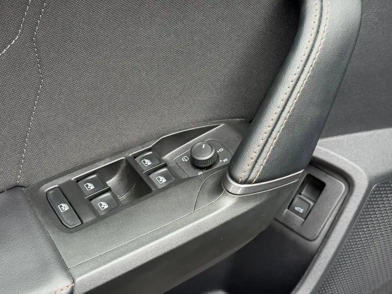 Détail des commandes de lève-vitres et réglage des rétroviseurs sur la porte côté conducteur d'une CUPRA Formentor bleu.