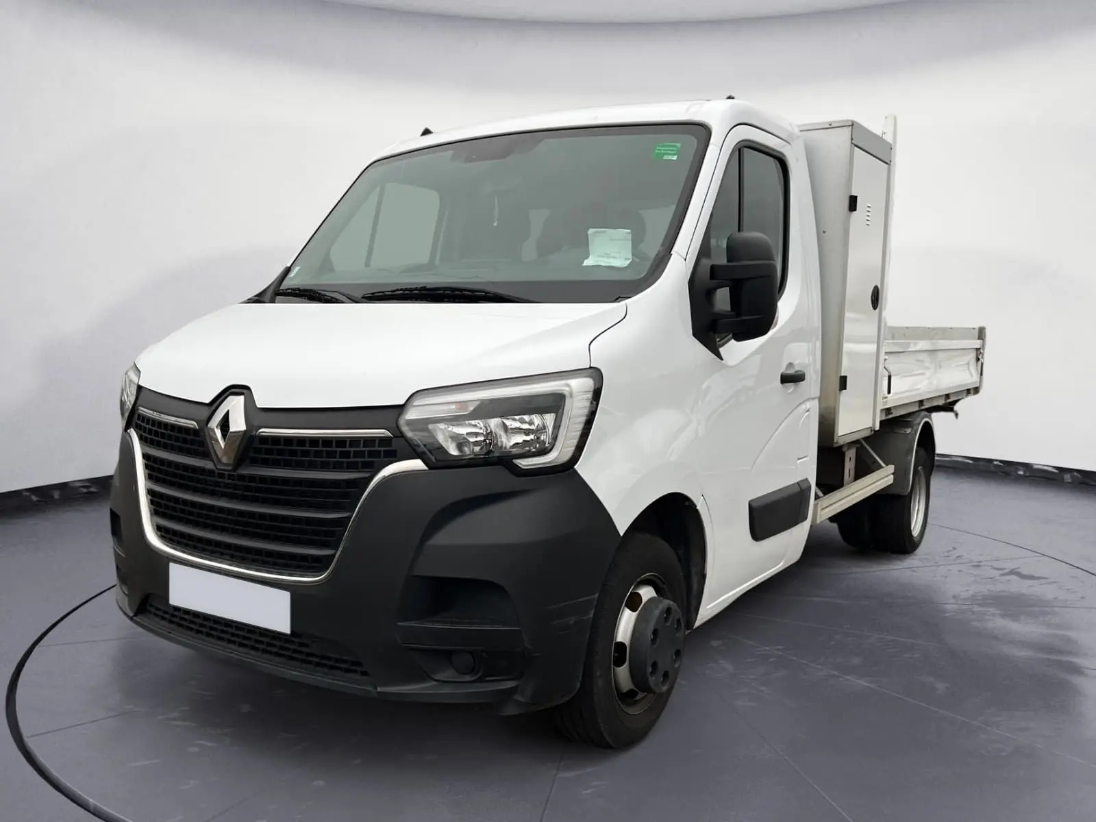 Vue 3/4 avant droit d'un Renault Master Châssis Cabine blanc avec benne et coffre, roues jumelées arrière visibles.