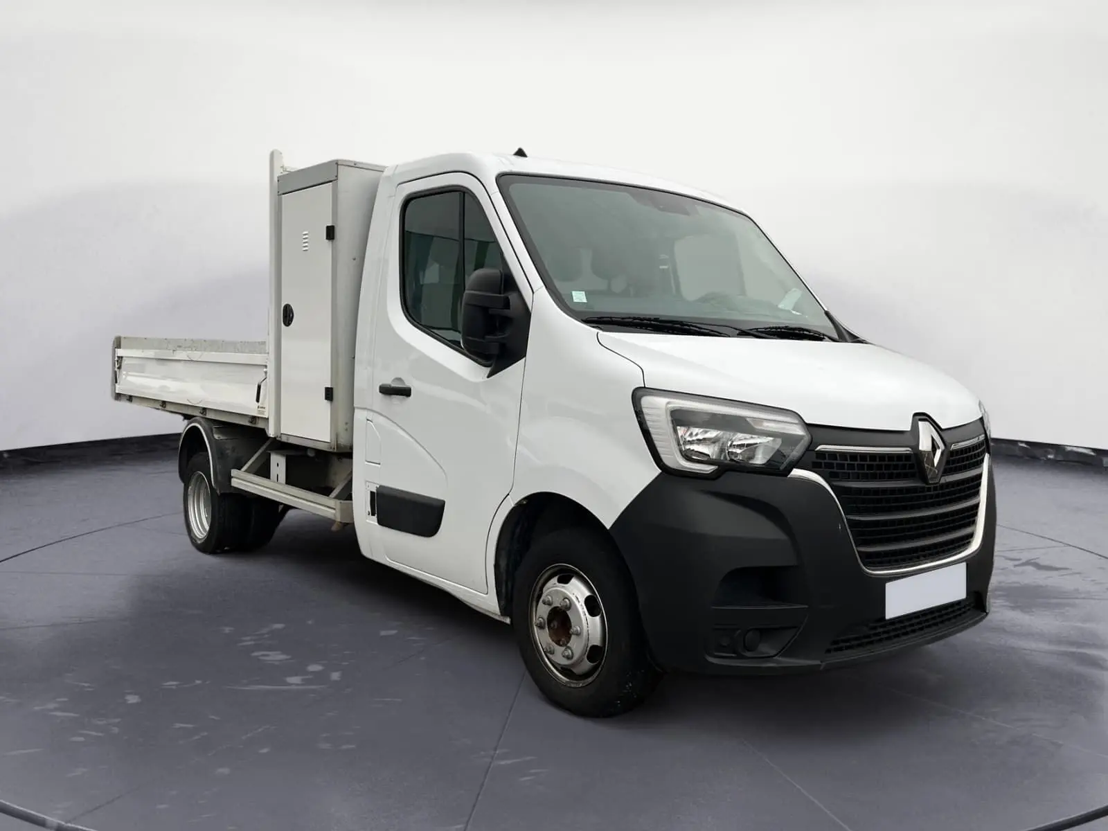 Renault Master Châssis Cabine blanc en 3/4 avant droit, avec benne, coffre latéral et roues jumelées arrière.