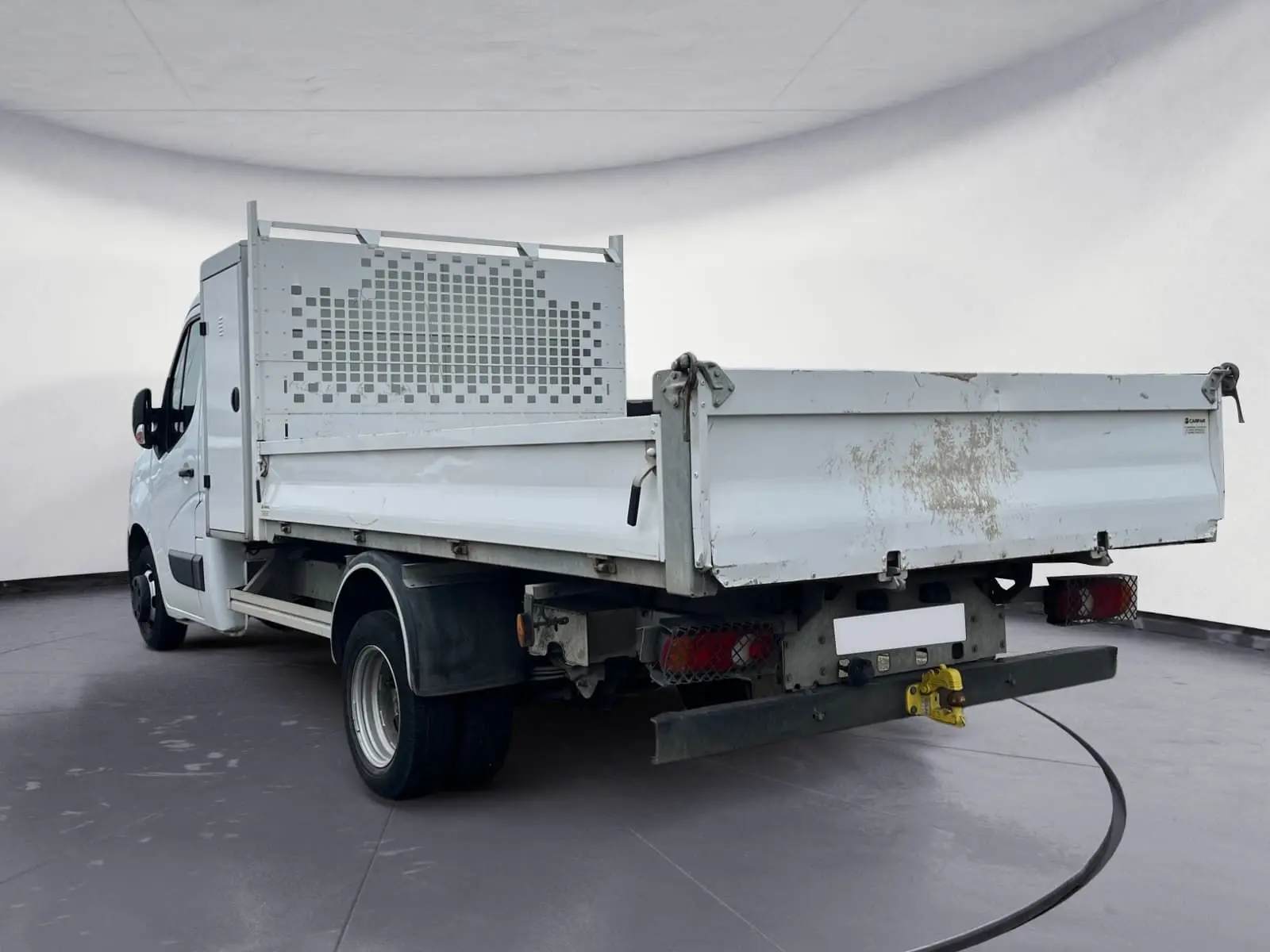 Vue 3/4 arrière droite d’un Renault Master Châssis Cabine blanc avec benne et coffre, roues jumelées et pare-éclats métallique.