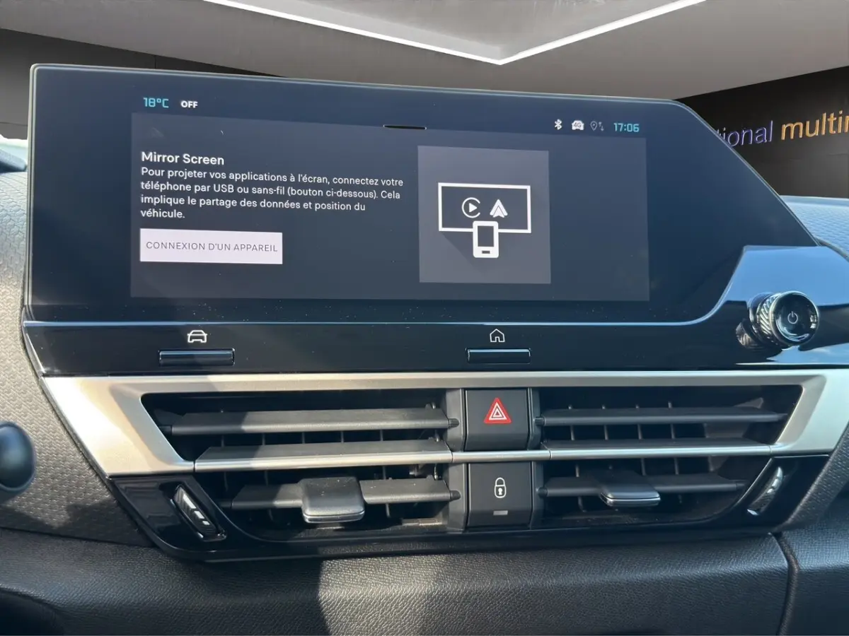 Vue rapprochée du tableau de bord central de la Citroën C4 hybride 2025, écran tactile et commandes d’aération visibles.