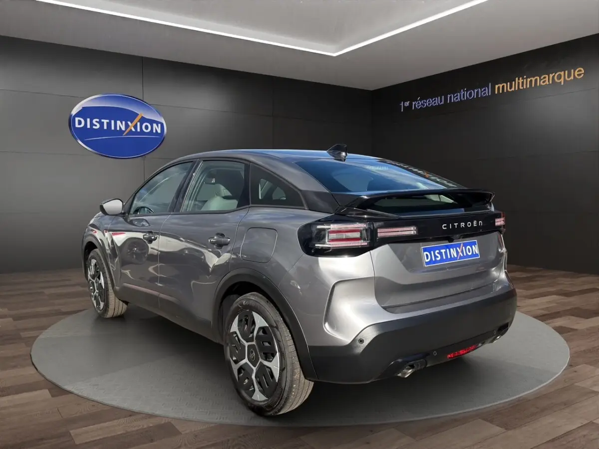 Vue 3/4 arrière droite d'une Citroën C4 hybride gris foncé avec feux arrière LED et toit noir brillant.