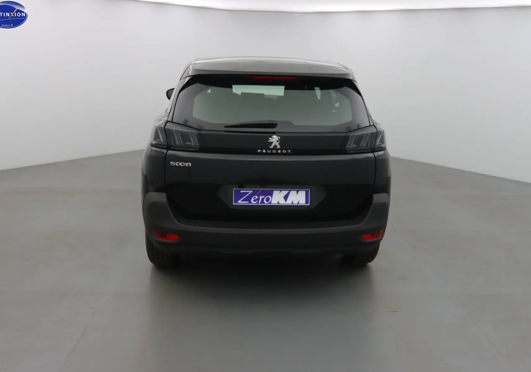 Vue arrière d'un Peugeot 5008 noir perle métal 2023 avec feux LED et plaque Zero KM visible.