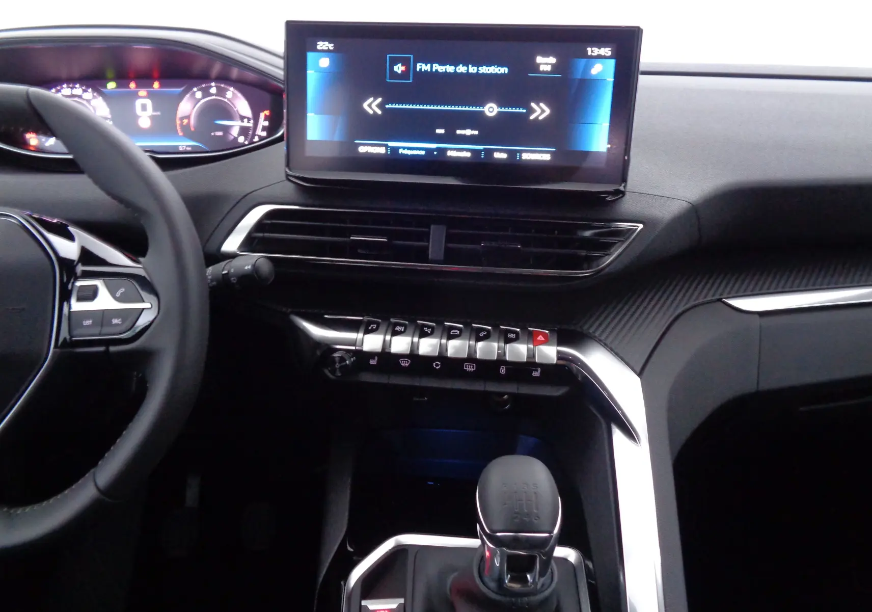 Vue intérieure du tableau de bord et console centrale du Peugeot 5008 2023 avec écran tactile et levier de vitesses manuel.