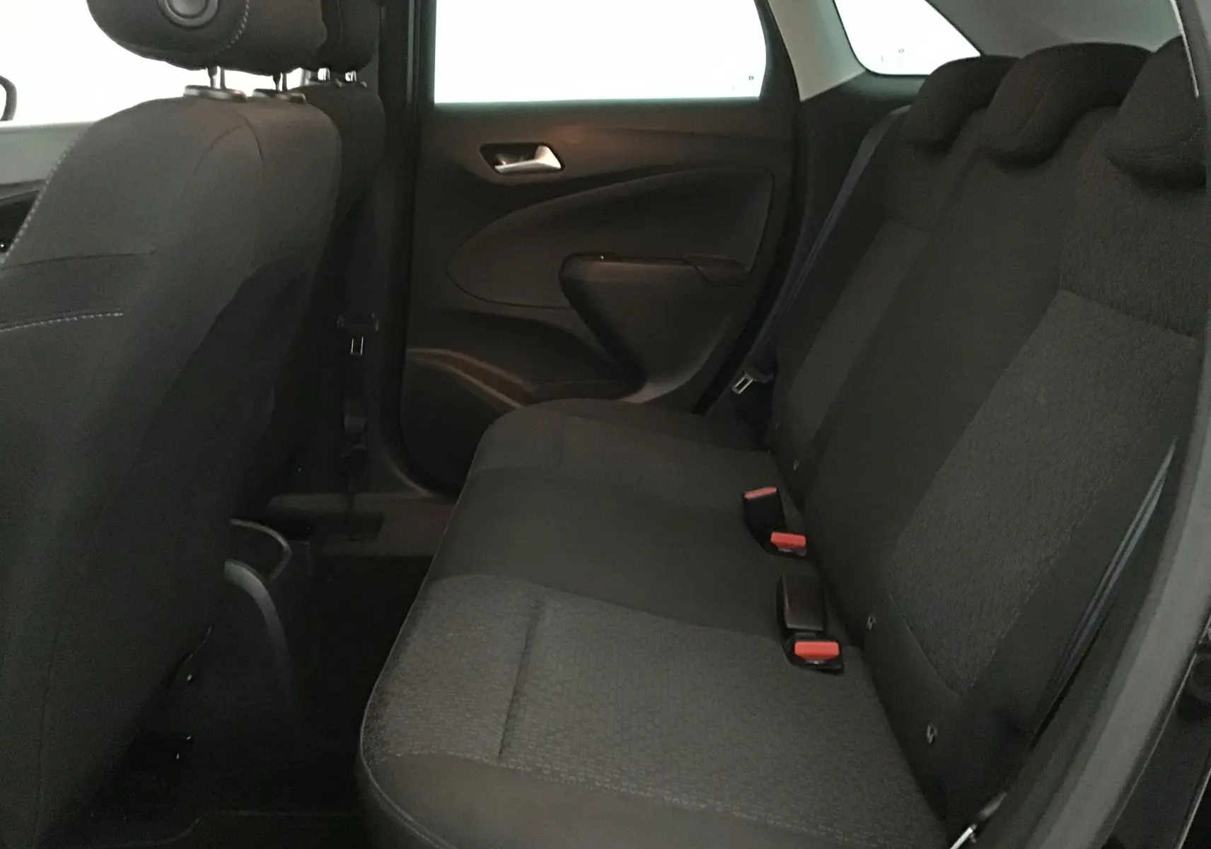 Vue intérieure côté droit des sièges arrière noirs de l'Opel Crossland 2022, finition élégante avec ceintures visibles.