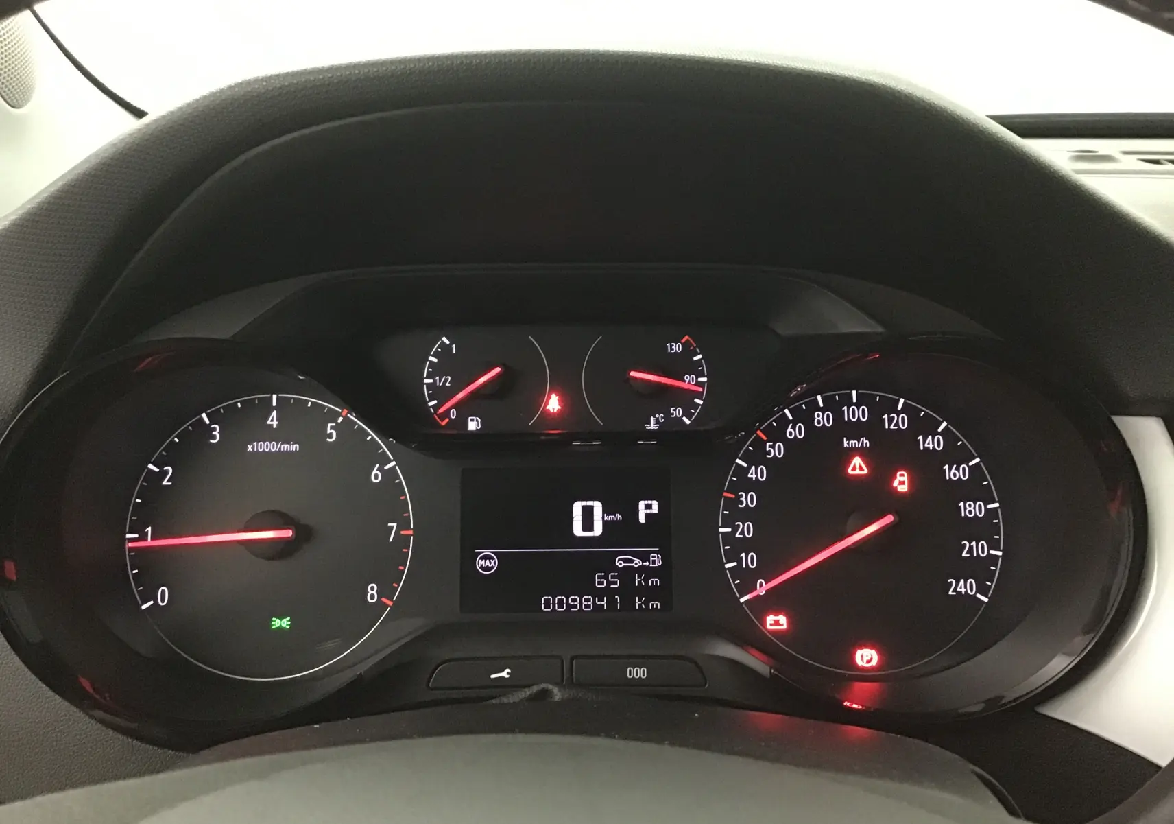 Vue rapprochée du tableau de bord noir de l'Opel Crossland 2022, affichant les compteurs et voyants allumés.